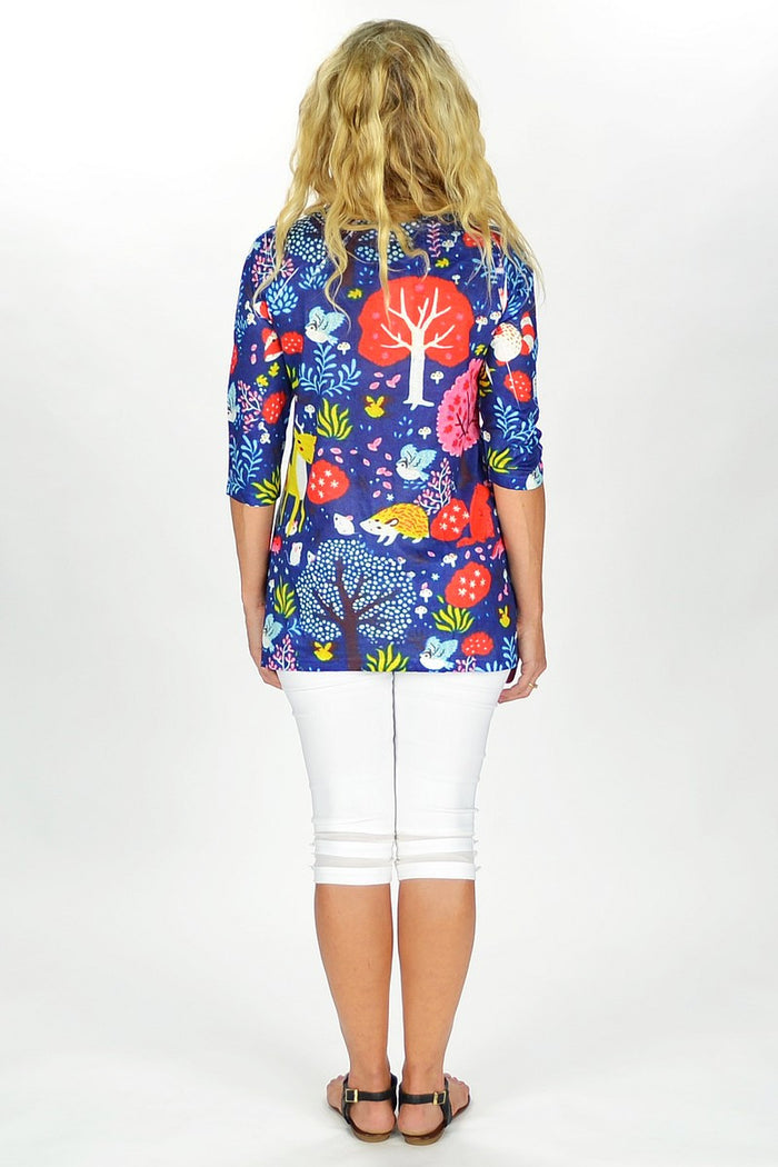 Fanny Lam Blue Forest Tunic displayed on a hanger, showcasing its flowy fabric and forest-inspired blue pattern.