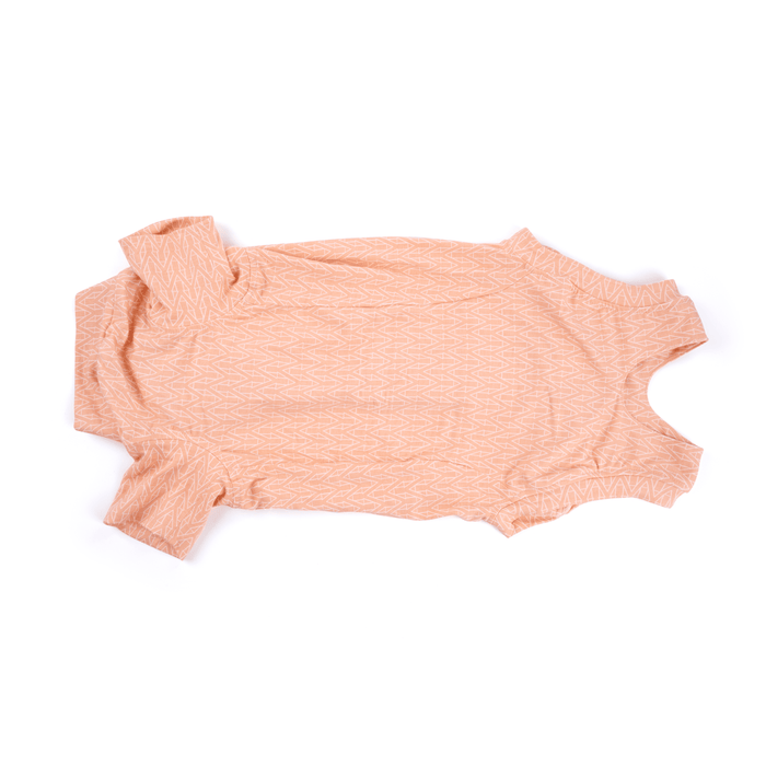 White background with a underneath view of a geometric peach bodysuits for dogs pictured.
