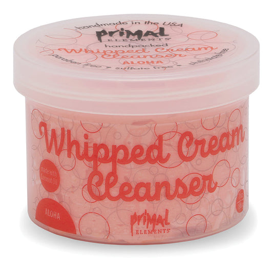 A jar of Aloha Whipped Cream Cleanser | Primal Elements in pink packaging featuring a whipped cream texture design, promoting gentle skincare with natural ingredients.