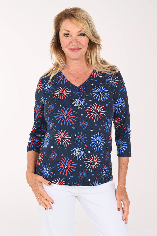 Woman wearing a navy 3/4 sleeve top with a firework print