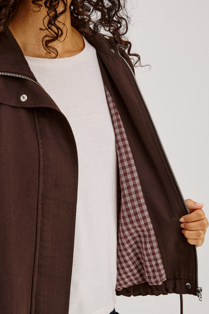 Blake Jacket in TENCEL™ Denim With Relaxed Fit, High Funnel Neck, Double Button Closures, Drop Shoulder Sleeves With Elastic Cuffs, and Cropped Drawstring Hem in Espresso Colorway - Upper Body Front View Featured on Model