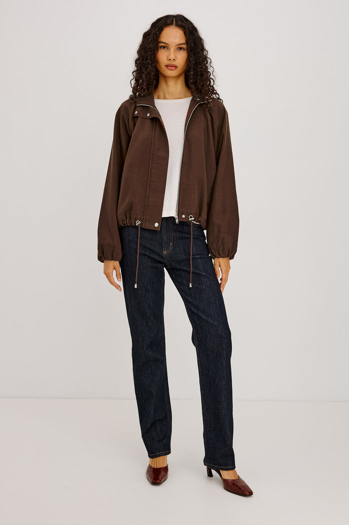 Blake Jacket in TENCEL™ Denim With Relaxed Fit, High Funnel Neck, Double Button Closures, Drop Shoulder Sleeves With Elastic Cuffs, and Cropped Drawstring Hem in Espresso Colorway - Full Body Front View Featured on Model