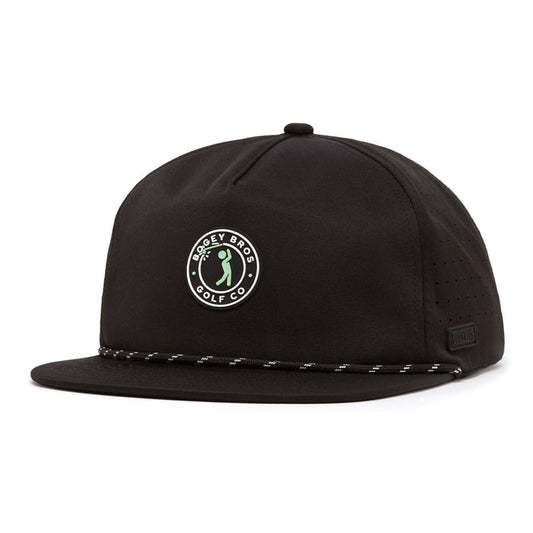 The Bogeyman Stamp Black Unstructured Flat Bill Hat is a black snapback featuring a circular Bogey Bros Golf Co. logo with a green cartoon golfer, black and white rope across the brim, and side ventilation holes.