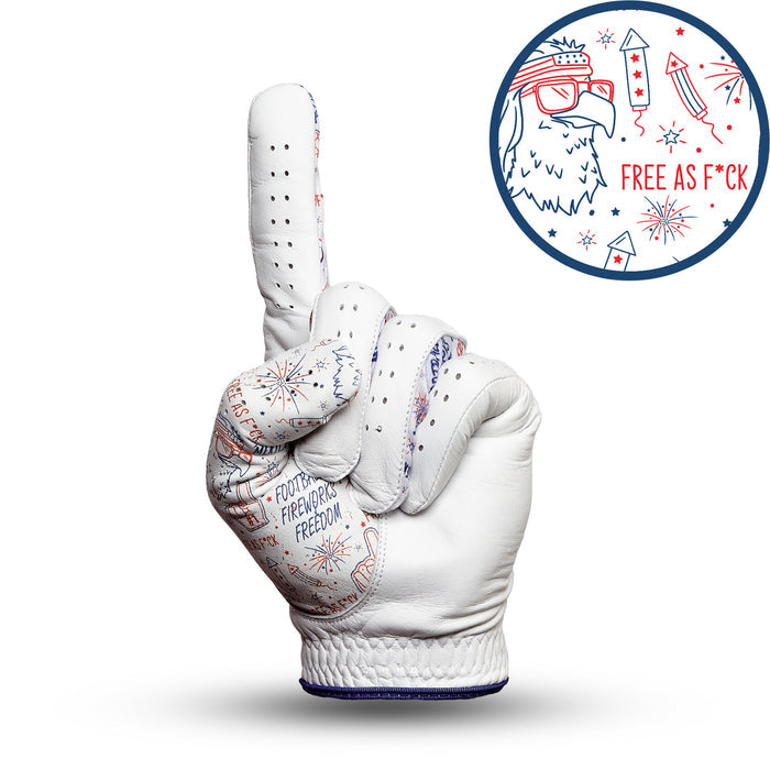 The 'Merica - Glove is a white golf glove shaped like a hand making a “number one” gesture, with red and blue fireworks, “FOUNDING FATHERS FREEDOM,” and an inset eagle head in bandana, “FREE AS F*CK” text—all in patriotic colors.