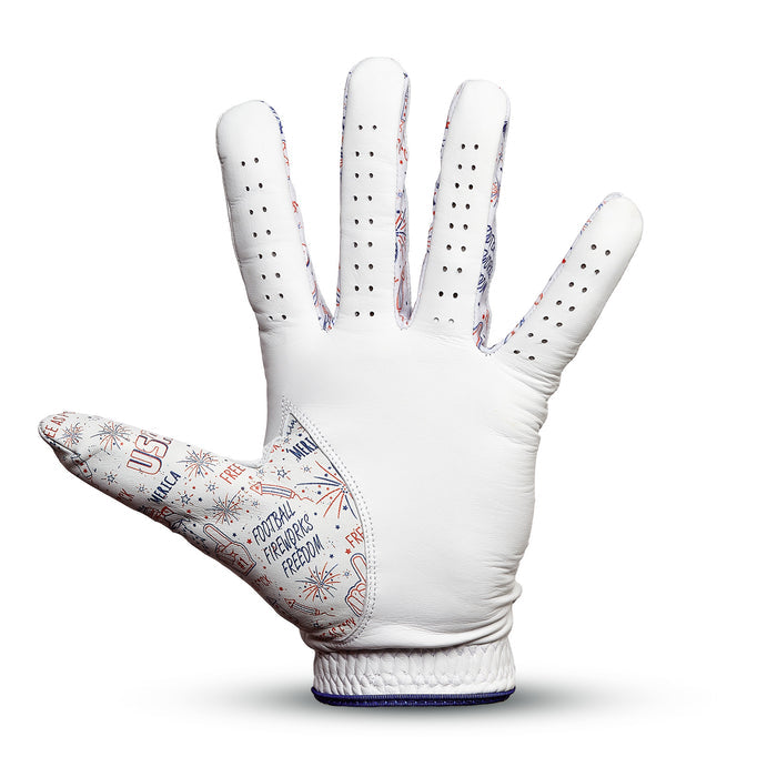 The 'Merica - Glove is a white Cabretta leather golf glove with small finger vents, red and blue USA and FREEDOM patterns, a precision fit, and a textured snug cuff, shown upright with the palm facing forward.