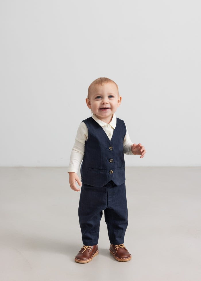 Baby wearing dark blue vest, shirt and pants in festive Christmas baby outfit