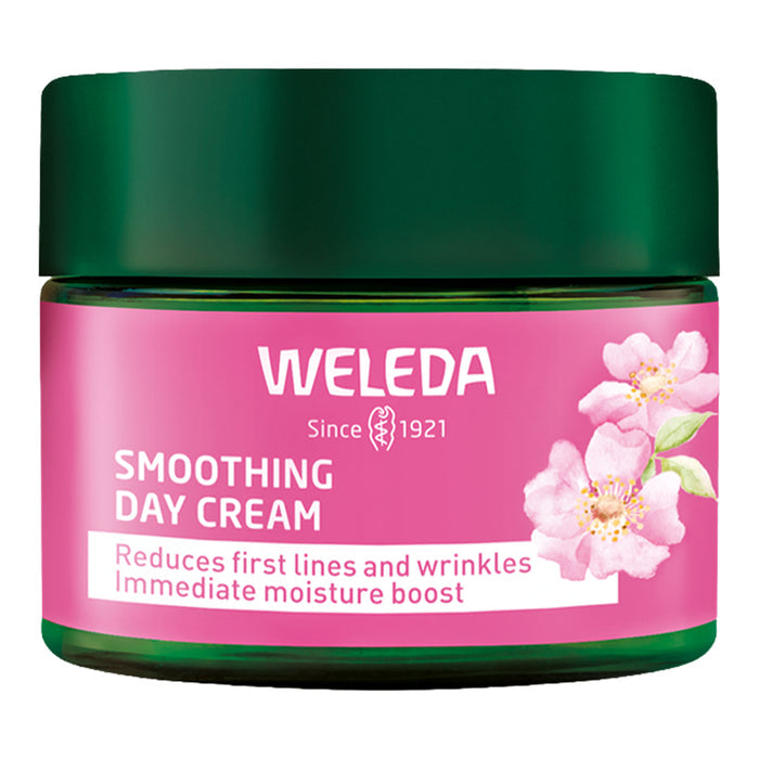 Weleda smoothing day cream jar with pink label and green lid on a white background.