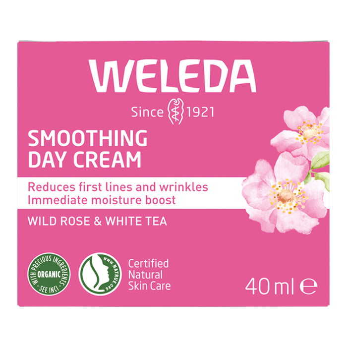 Weleda smoothing day cream packaging with pink background and floral design.