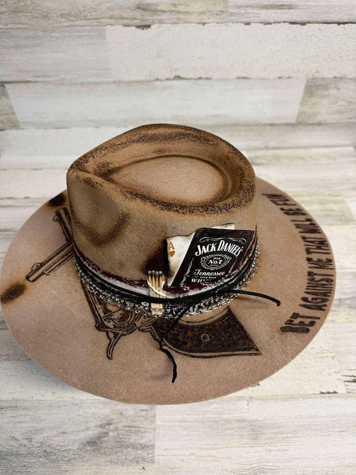 Brown cowboy hat with Jack Daniel's label and gun design.