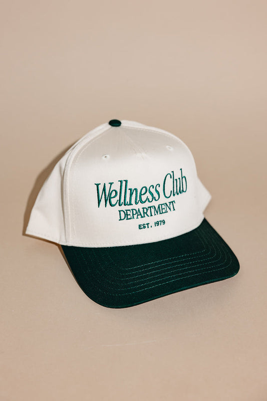 White and green Wellness Club Department Hat | Lucky Owl with embroidered text and contrasting bill against a neutral background, showcasing casual style and comfort.