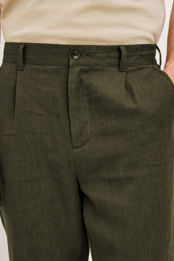 Zimmer Pant in Cotton Linen Wool Blend With Relaxed Fit, Tapered Leg, Side Pockets, Zip Fly, Belt Loops, and Back Welt Pockets in Deep Olive Colorway - Lower Body Front View Featured on Model